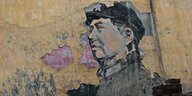 Ein an den Rändern bröckeliges Mao-Graffiti an einer Hauswand.