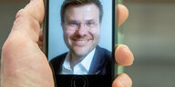 CSU Politiker Marcus König auf dem Bildschirm eines Smartphones.