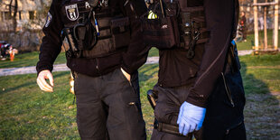 Polizisten mit Schutzhandschuh in einem Park.