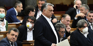 Victor Orbán steht als einziger, die Parlamentarier sitzen um ihn herum