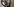 Mann mit Mundschutz hält am Rosa-Luxemburg-Platz ein Grundgesetz in die Luft
