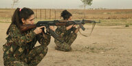 Zwei Frauen im Kampfuniform trainieren mit dem MG