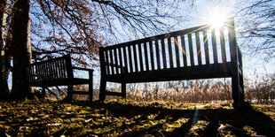 Zwei Parkbänke in der Frühlingssonne