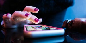 Finger über dem Touchscreen eines Smartphones