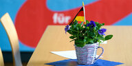 Eine Blume mit Deutschlandfahne auf einem Tisch.