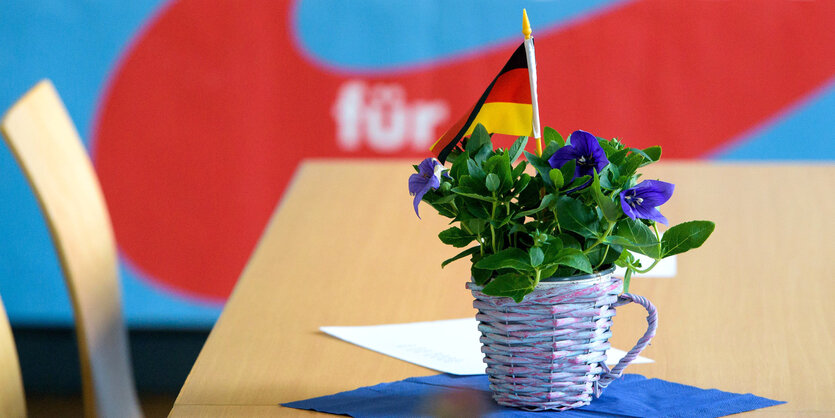 Eine Blume mit Deutschlandfahne auf einem Tisch.