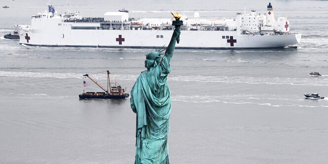 Ein Rotekreuzschiff fährt an der Freiheitsstatue vorbei.