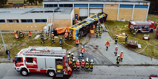 Feuerwehrleute stehen um einen umgestürzten Bus