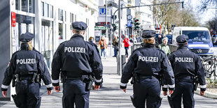 Rückenansicht von vier Polizisten auf der Streife