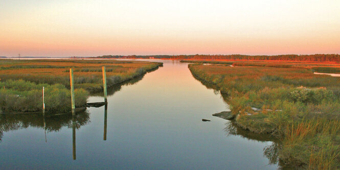 eine Landschaft, in der Mitte ein Fluss, der zum Horizont läuft