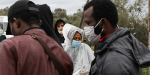 Flüchtlinge in Moria tragen Mundschutzmasekn