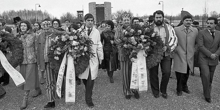 Roma und Sinti mit Gedenksträußen auf dem Gelände der KZ-Gedenkstätte Dachau.