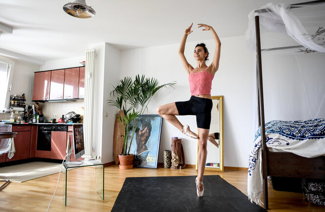 Selbstständige und Corona: Eine Ballerina tanz in ihrem Wohnzimmer. Es gibt nicht allzu viel Raum für ihre Übungen