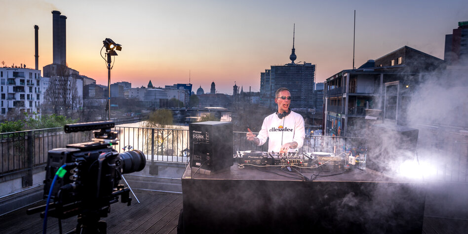 Corona und Kulturschaffende: Ein DJ legt vor einer Kamera auf einem Dach auf. Er ist dort ganz alleine.
