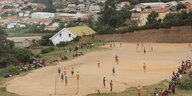 Blick auf ein Fußballfeld inmitten eines Dorfes