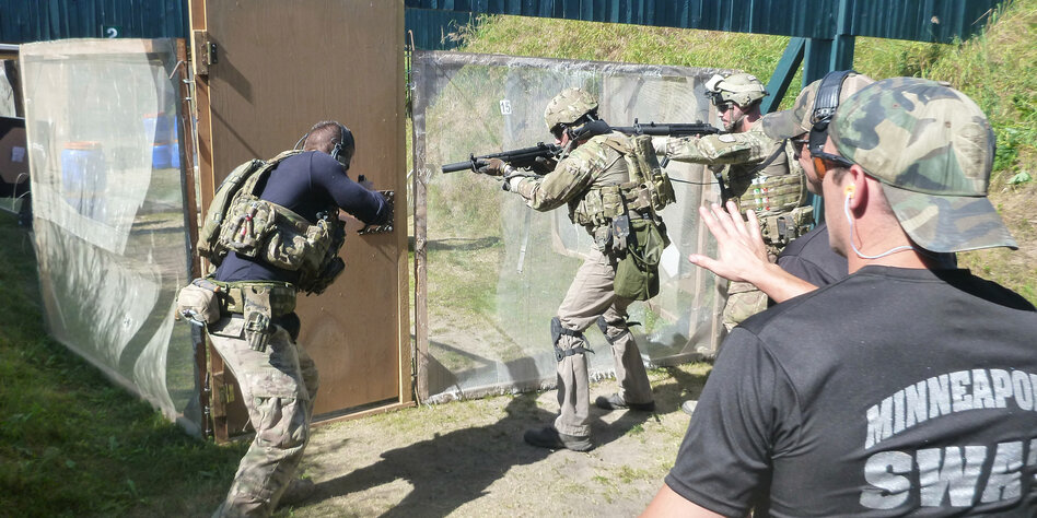 Schwerbewaffnete Polzisten in Tarnuniform und Gewehren in der hand