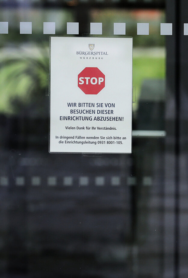 Ein Zettel mit einem Stoppschild hängt an einer Glastür
