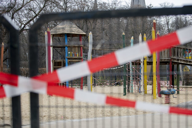 blick auf einen mit rot-weißen absperrbändern abgeriegelten Spielplatz