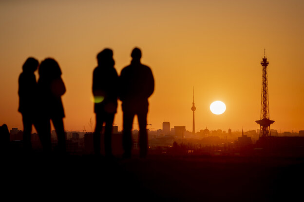 vier menschen stehen auf einem Berg vor dem Sonnenuntergang