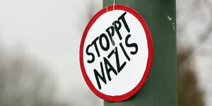 "Stoppt Nazis" steht auf einem Schild an einem Baum.