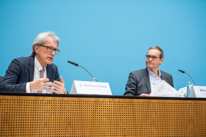 zwei Politiker sitzen auf einem Podium