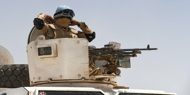 Soldat mit festinstallierter Waffe auf Fahrzeug