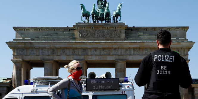 Polizist und Polizeiwagen vor dem Brandenburger Tor