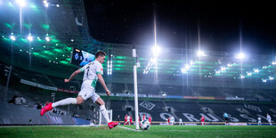 Patrick Herrmann, ein Spieler von Borussia Mönchengladbach, schießt eine Ecke. Das Stadion ist leer.