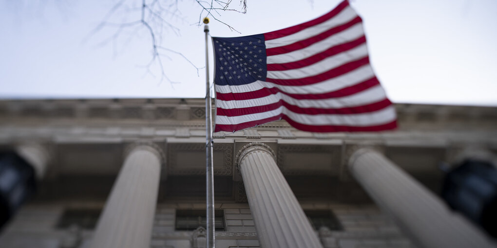 Flagge der USA vor unscharfem Hintergrund.