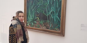 Tetjana Duman-Skop steht vor einem Gemälde