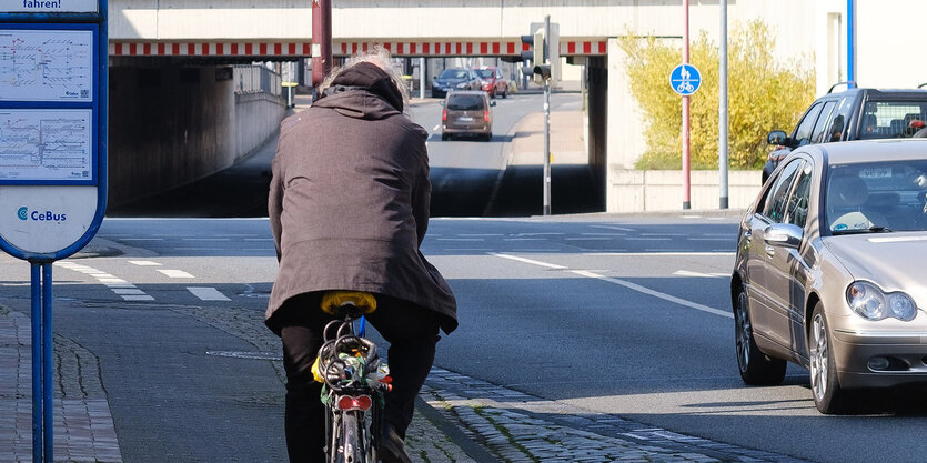 eine Fahrradfahrrerin passiert eine Bushaltestelle