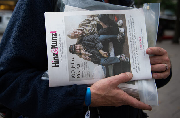 Ein Verkäufer hält mehrere Exemplare der Zeitschrift "Hinz&Kunzt" in einer Plastikhülle.