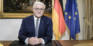 Frank-Walter Steinmeier am Schreibtisch - im Hintergrund eine Deutschland- und eine EU-Fahne und ein Gemälde