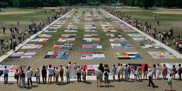 Im Central Park liegen bunte Gedenk-Decken. Menschen einen Kreis gebildet