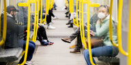 Menschen sitzen in einer fast leeren U-Bahn