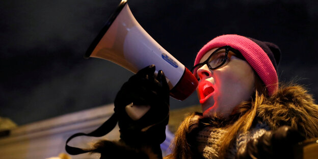Eine Demonstrantin mit einem Megafon