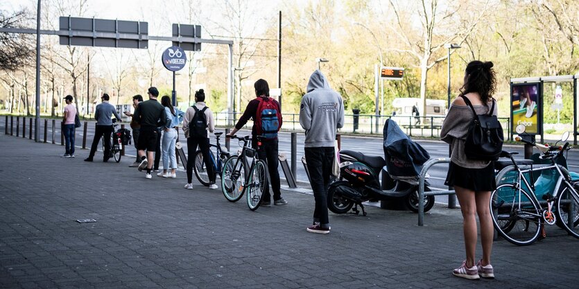 Menschen stehen Abstand haltend in einer Schlange