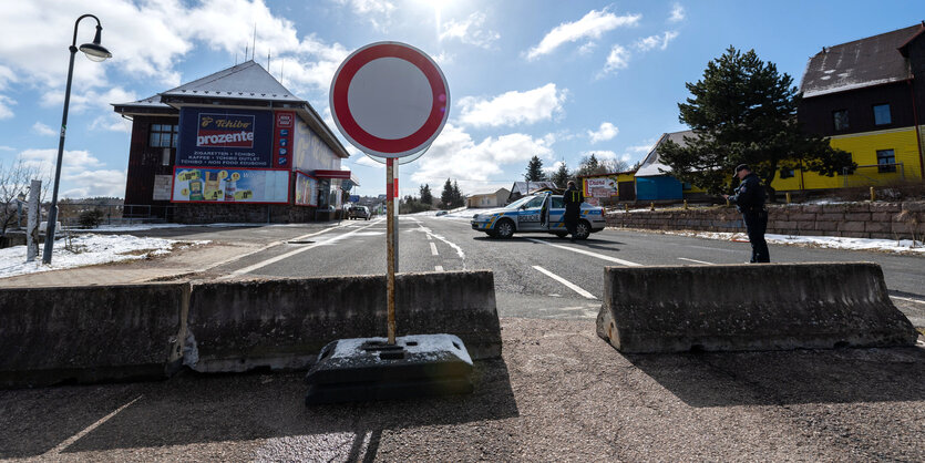 Tschechische Polizisten stehen zur Einreisekontrolle auf einer blockierten Straße