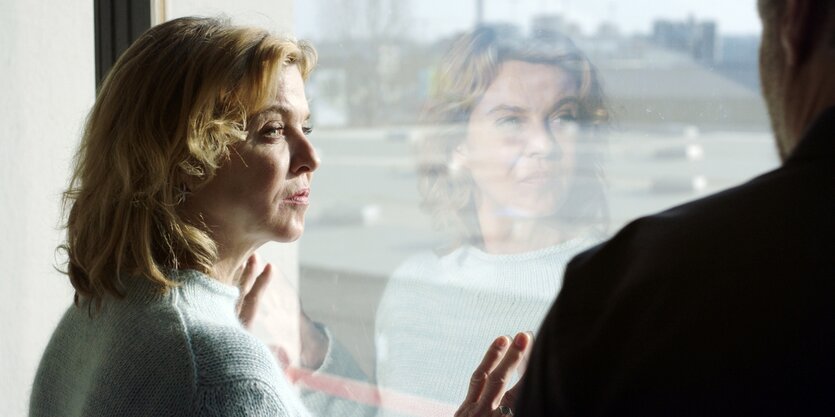 Frau steht an einem Fenster (Filmstill)