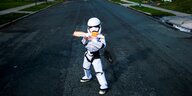 Ein Junge steht als Jedi-Ritter auf der Strasse