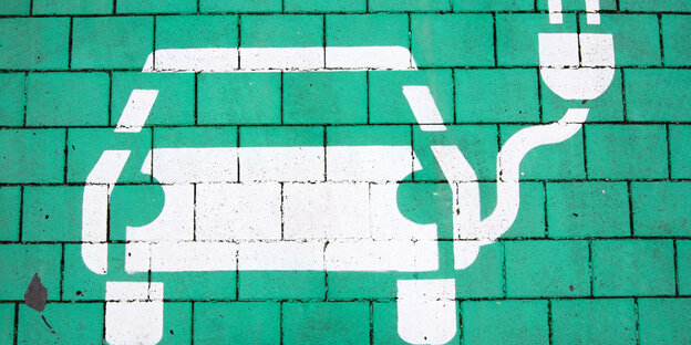 Gemalites Elektroauto mit Ladekabel auf grünem Untergrund
