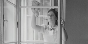 Eine Frau putzt Fenster