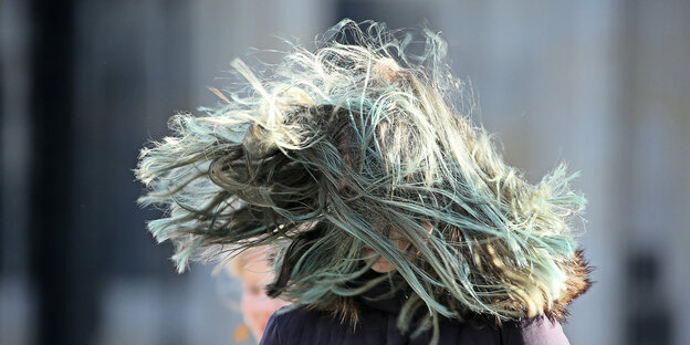 Haare einer Frau fliegen im Wind