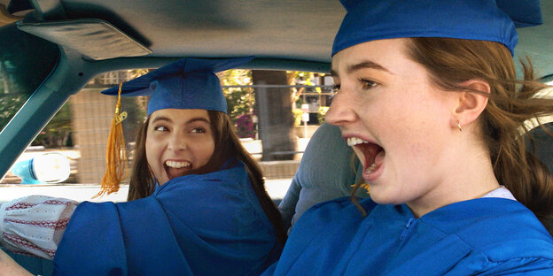 zwei Highschool-Schülerinnen sitzen im Auto und kreischen
