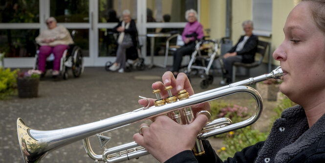 Eine Musikerin vor einem Frankfurter Pflegeheim