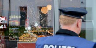 Einschlagstellen von Steinwürfen sind in der Fensterscheibe einer Bäckereifiliale