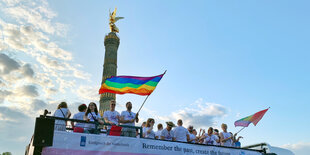 Ein Truck mit Bannern und oben auf Menschen mit Regenbogenfahnen: Teilnehmer der CSD-Parade 2019 kommen mit einem Umzugstruck an der Siegessäule an.