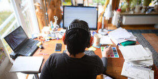 e Frau arbeitet mit Hörschutz im Homeoffice.