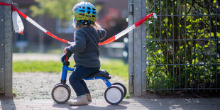 Frida steht vor einem abgesperrten Spielplatz