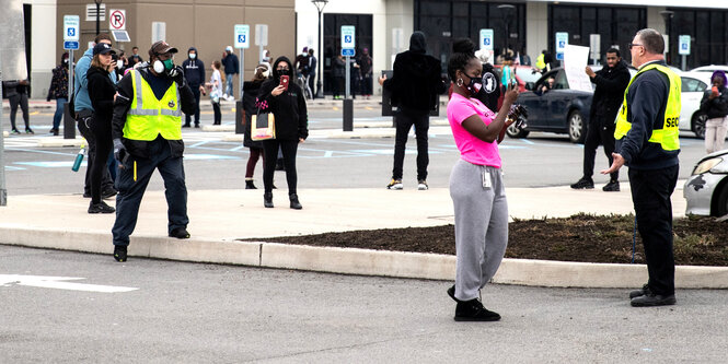 Pressevertreterinnen und Mitarbeiterinnen vor einem Amazon-Gebäude in Staten Island